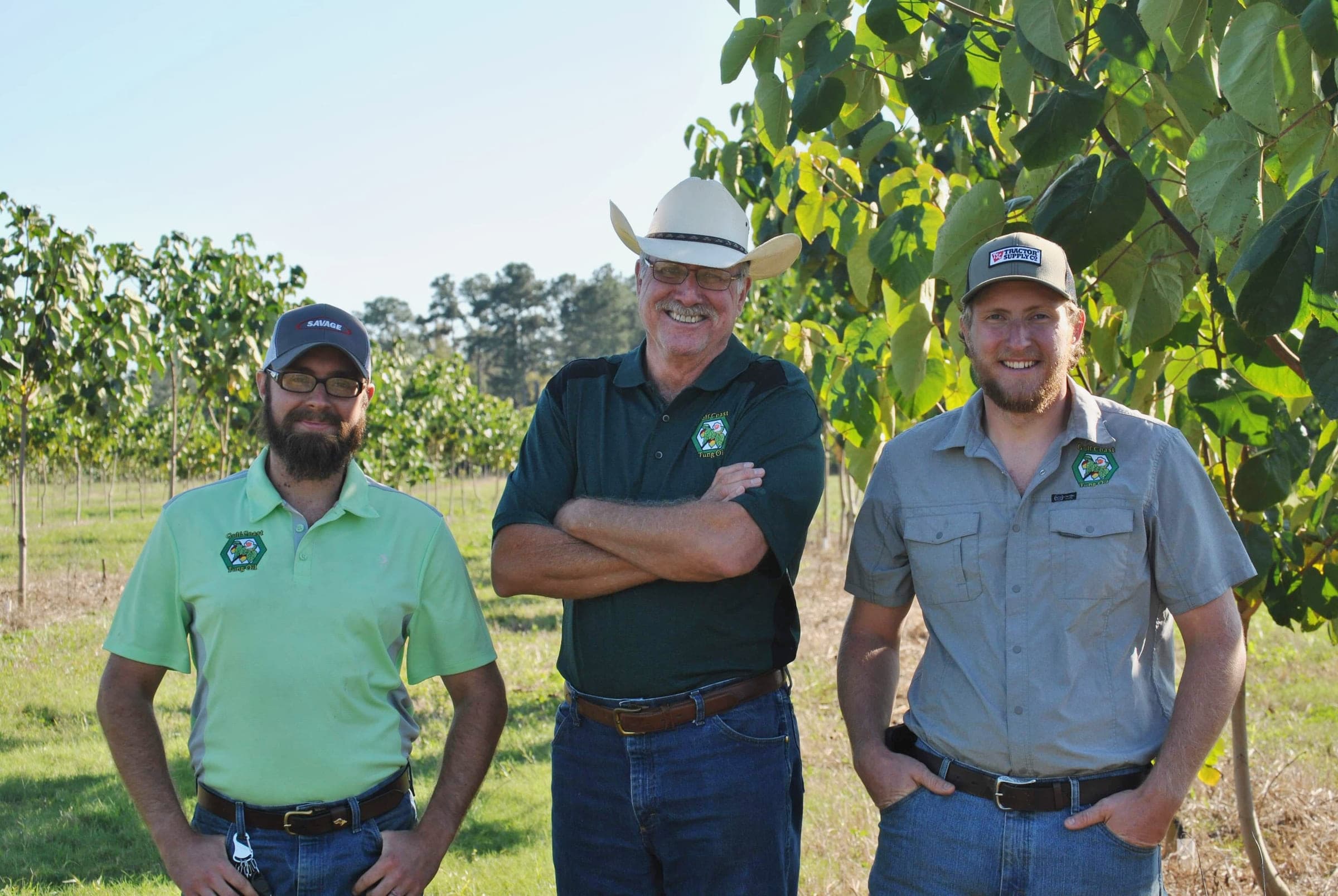 Three of the crew standing in the orchard