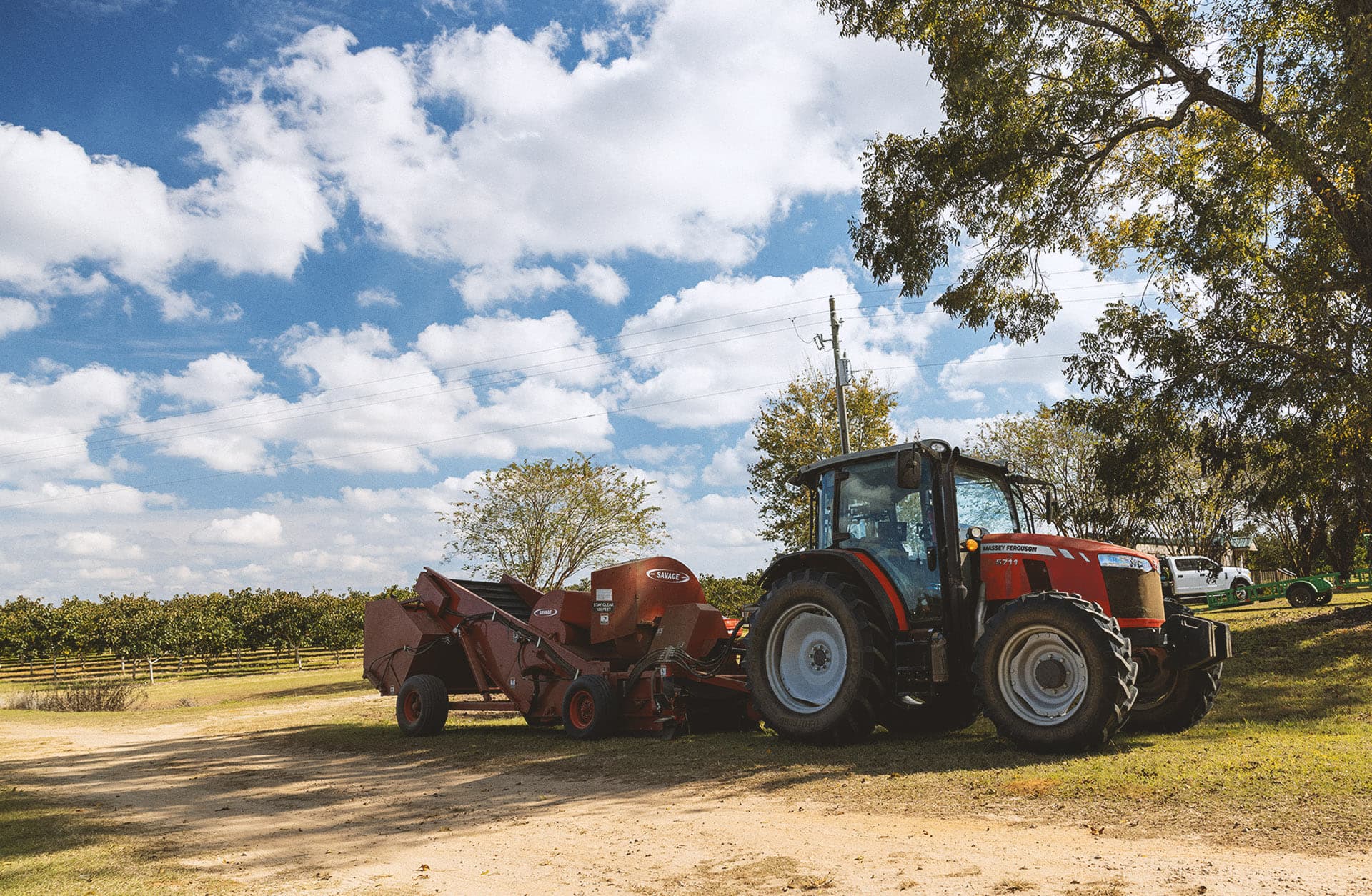 Tractor and harvester, waiting at the edge of the orchard.